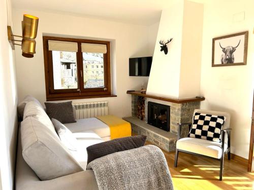 a living room with a couch and a fireplace at Apartament amb llar de foc i balcó amb vistes de la vall by RURAL D'ÀNEU in Esterri d'Àneu