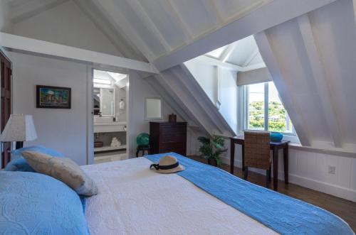 a bedroom with a bed with a hat on it at Admiral's Inn and Gunpowder Suites in English Harbour Town