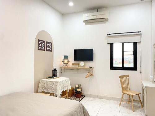 a bedroom with a bed and a table and a tv at Click Residence, Si Muang in Vientiane