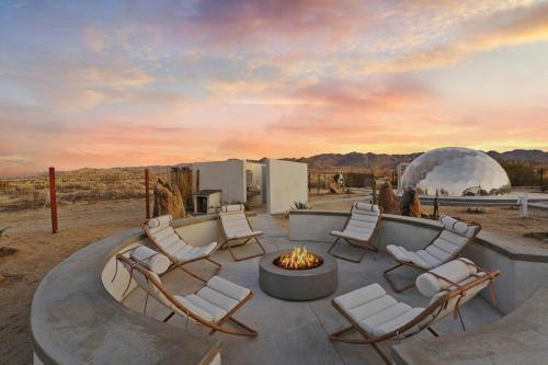 a group of chairs sitting around a fire pit at Quail Wash Retreat - Star Dome I Sauna I Plunge I Spa in Joshua Tree