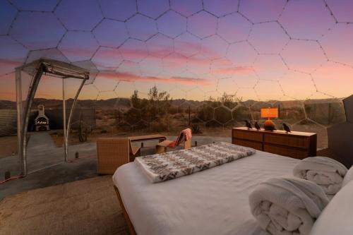 a bed in a room with a view of the desert at Quail Wash Retreat in Joshua Tree
