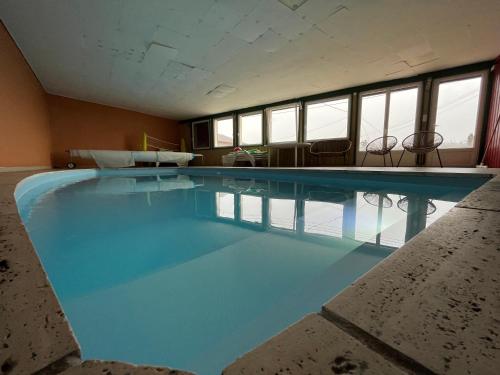 - une grande piscine dans une pièce dotée de fenêtres dans l'établissement Aux balcons des xettes, à Gérardmer