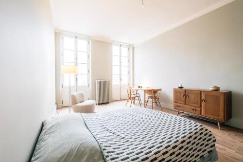 une chambre blanche avec un lit et une table dans l'établissement Chambre Josephine, à Nancy