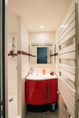 La salle de bains est pourvue d'une armoire rouge et d'un lavabo. dans l'établissement Chambre Josephine, à Nancy