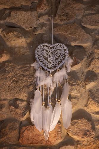 a heart shaped chandelier hanging on a stone wall at Masia Cal Fuster in Joanet