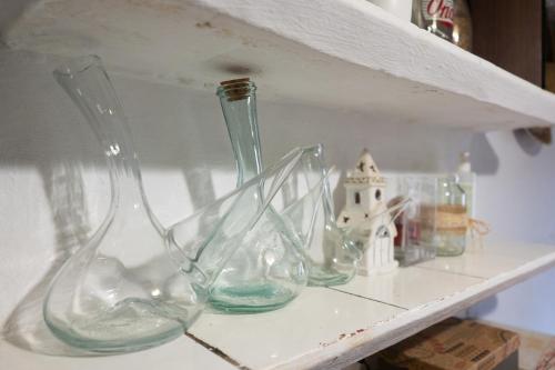 four glass vases sitting on a shelf at Masia Cal Fuster in Joanet