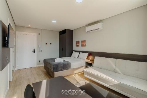 a hotel room with a bed and a couch at TCO - Apartamentos no Centro Histórico Porto Alegre/RS in Porto Alegre
