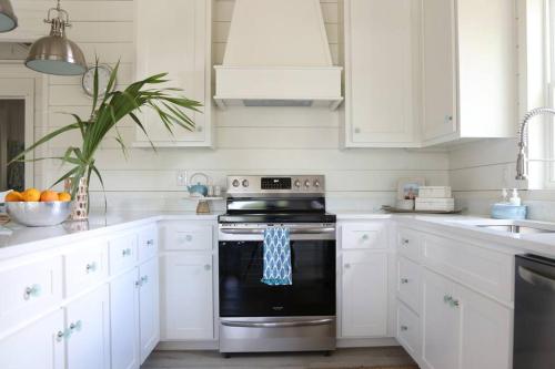 a kitchen with white cabinets and a black oven at Weekend Away in Dauphin Island