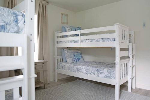 two white bunk beds in a room at Weekend Away in Dauphin Island