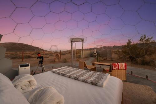 a man taking a picture of the desert with a camera at Quail Wash Retreat - Star Dome I Sauna I Plunge I Spa in Joshua Tree