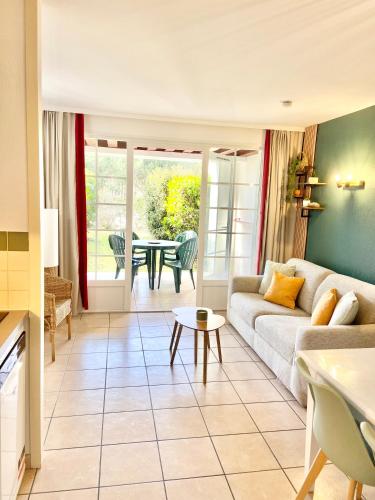 un salon avec un canapé et une table dans l'établissement BISCARROSSE Charmant T2 Au cœur du Golf avec piscine Entre Lac & Océan - Ménage inclus, à Biscarrosse