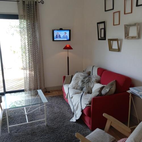 un salon avec un canapé rouge et une lampe rouge dans l'établissement valemare, à Rivedoux-Plage