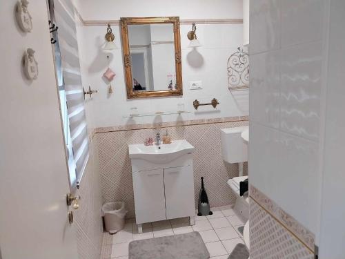 a white bathroom with a sink and a mirror at AUTOMOTODROM GROBNIK - Apartments and Rooms Skejić in Čavle