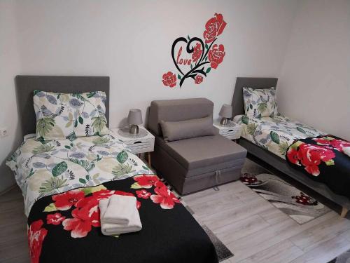 a bedroom with two beds and a chair at AUTOMOTODROM GROBNIK - Apartments and Rooms Skejić in Čavle