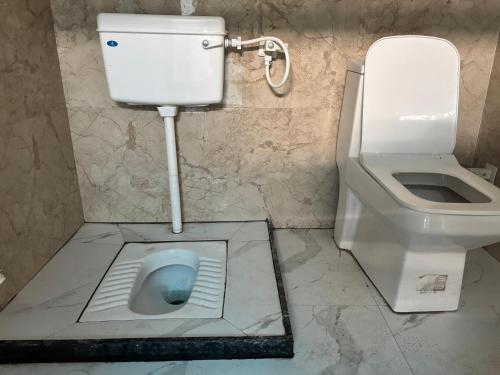 a bathroom with a toilet and a bidet at Shri Gaya Prasad Dham in Vrindāvan
