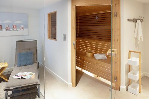 un bagno con doccia con panca e porta in vetro di Landsend a List