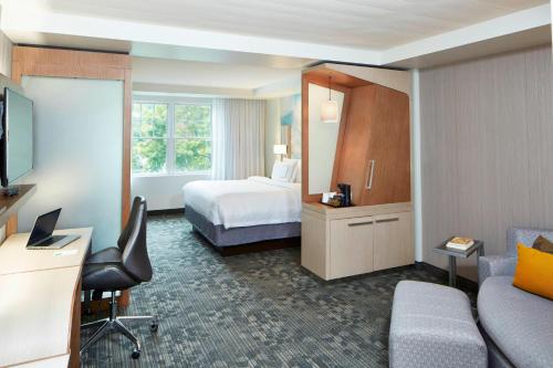 a hotel room with a bed and a desk at Courtyard by Marriott Lake George in Lake George