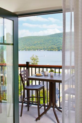 a table and chairs on a balcony with a view of the water at Courtyard by Marriott Lake George in Lake George