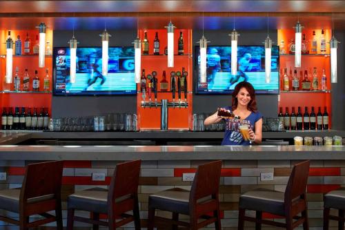 a woman standing at a bar with a drink at Courtyard by Marriott Lake George in Lake George