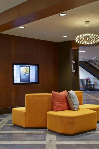 a yellow couch with pillows on it in a lobby at Courtyard by Marriott Lake George in Lake George