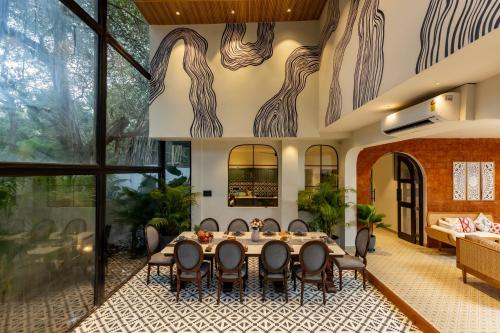 a dining room with a table and chairs at 6BR Luxe Villa with Pool Near Beach in Candolim