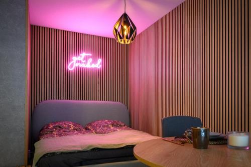 a bedroom with a bed with a table and a neon sign at Stilvolle Wohnung am Zwinger in Dresden