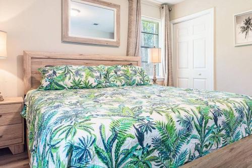 a bedroom with a bed with a blue and green bedspread at Cottage in the Pines in Dauphin Island