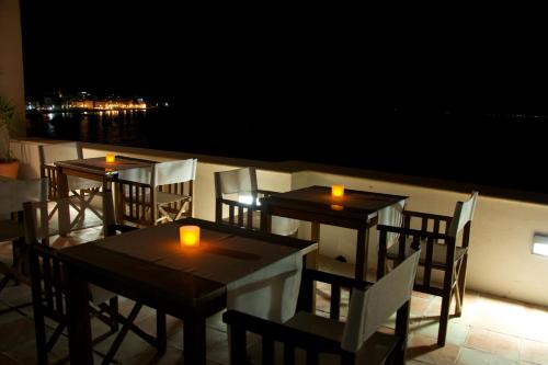 two tables and chairs with candles on a balcony at night at Villa Lieta in Ischia