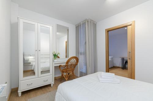 a white bedroom with a bed and a desk at Oasis de elegancia by CABANA Rentals in Vigo