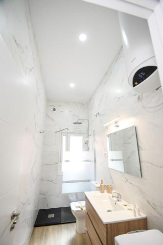 a white bathroom with a sink and a toilet at Modern Oasis in Vallecas in Madrid