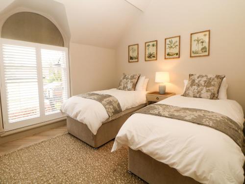 two beds in a room with a window at Chatsworth Suite in Buxton