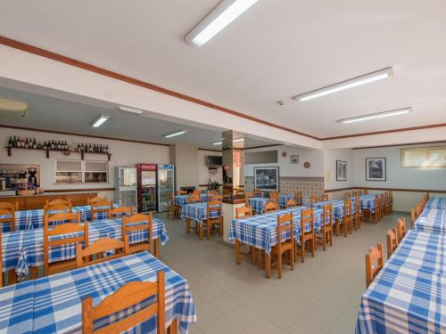 a restaurant with blue and white tables and chairs at Alojamento Correia in Caldelas