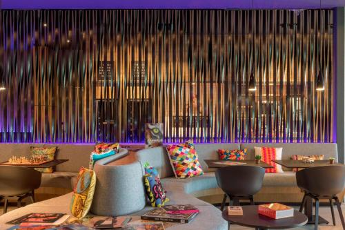 a restaurant with tables and chairs and a wall of sticks at X Hotel in Skjetten