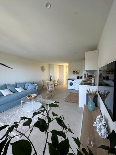 un salon avec un canapé bleu et une cuisine dans l'établissement Le Bleu de Giens, à Hyères