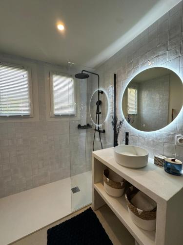 une salle de bain avec un lavabo et une douche avec un miroir dans l'établissement Le Bleu de Giens, à Hyères