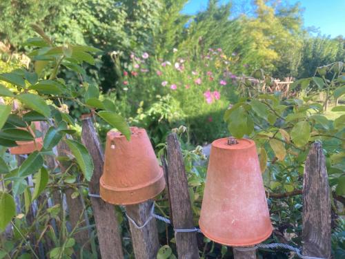 two copper bells hanging on a wooden fence at Ferme St Pierre gîte, pisc, repas, 2-3 personnes in Chabeuil