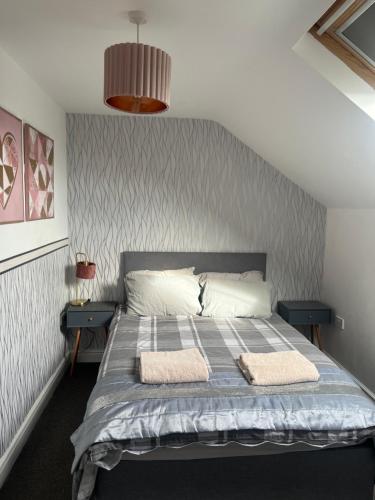 a bedroom with a bed with two towels on it at Quiet cottage, Ryan Anglesey in Holyhead