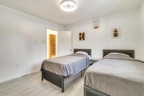 two beds in a room with white walls and wooden floors at Less Than 7 Mi to Slopes Inviting Pocono Mtn Retreat! in Albrightsville