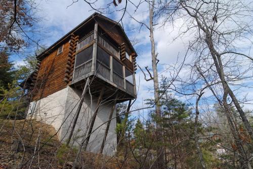 a tree house with a balcony on the side of it at Tennessee Twilight Cabin in Sevierville