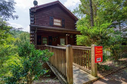 a log cabin with a wooden fence and a sign at Tennessee Twilight Cabin in Sevierville