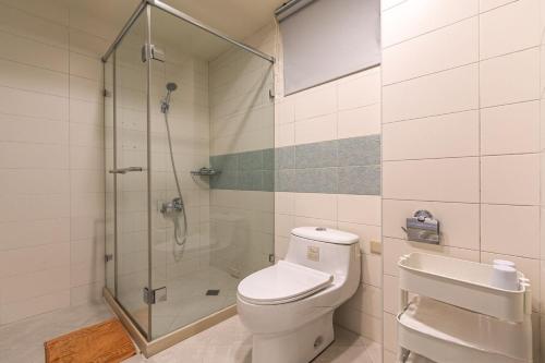 a bathroom with a shower and a toilet and a sink at 宜蘭小綠丘民宿 in Luodong