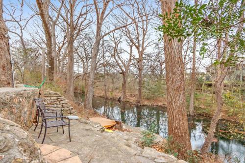 a couple of chairs sitting next to a river at Owl Lodge in Wimberley