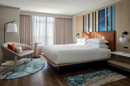 a hotel room with a large bed and a chair at St. Petersburg Marriott Clearwater in St Petersburg