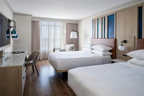 a hotel room with two beds and a desk at St. Petersburg Marriott Clearwater in St Petersburg