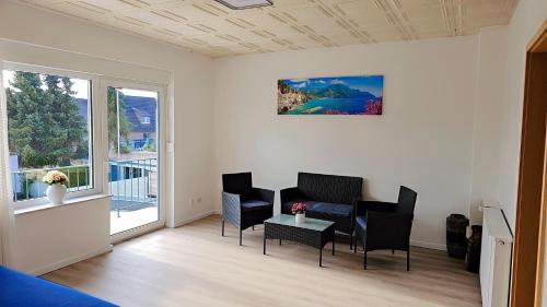 a living room with a table and chairs and a window at Beautiful 3 Room big Apartment with kitchen and Balcony in Kerpen