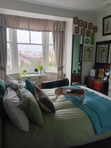 a bedroom with a large bed with a table on it at The Ocean Guest House in Weymouth