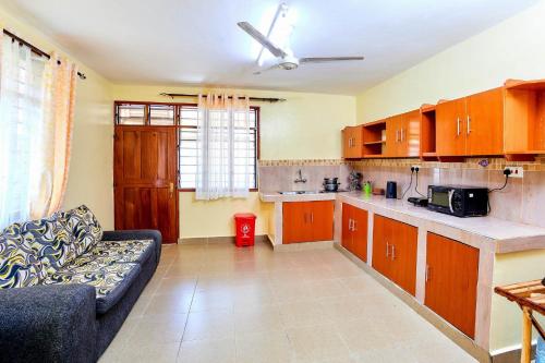 a living room with a couch and a kitchen at Diani Beach Gold Apartments in Diani Beach