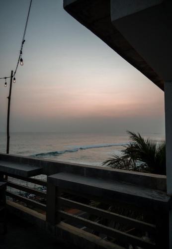 a view of the ocean at sunset from a balcony at Cocos in Midigama