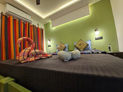 a bedroom with a bed with two stuffed animals on it at The Zen Zone in Varkala