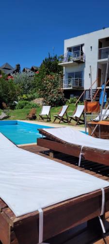 a swimming pool with lounge chairs next to a building at La Cumbre in Sierra de los Padres